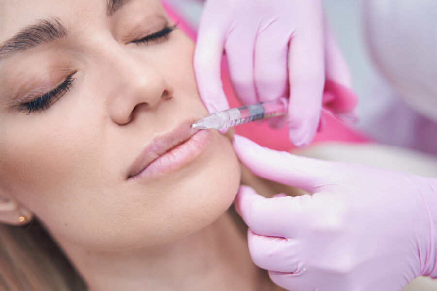Closeup portrait of serene young woman lying with her eyes closed during mesotherapy procedure